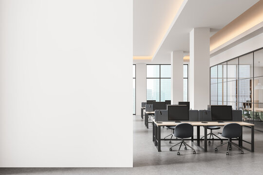 Empty white wall mockup in modern open space office with bright interior and computer desks, perfect for poster or banner design presentation template. 3D Rendering