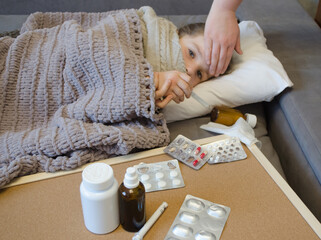 A little girl is lying in bed sick. The concept of illness, cold, acute respiratory viral infection