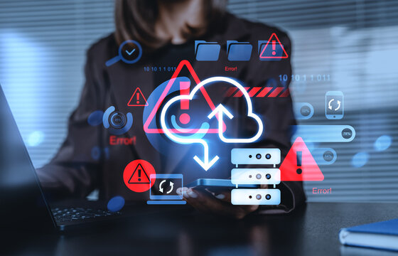 Cloud data storage error and cybersecurity risk concept with futuristic digital warning interface over professional using laptop and mobile device screen.