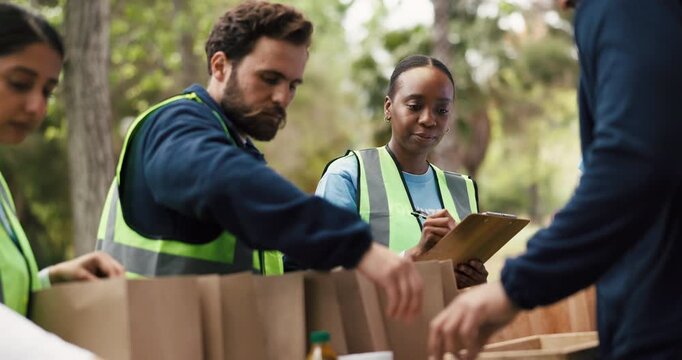 Volunteers, packages and people with clipboard, park and organizer with notes for inspection or talk. Outdoor, group and coordinator with checklist for inventory, donations and supply distribution