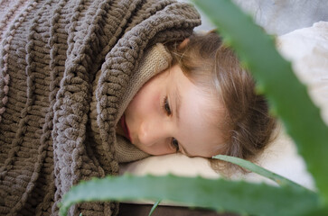A little girl is lying in bed sick. Aloe Vera Cold Cure	
