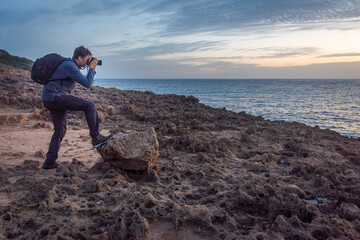 Nature photographer taking a photo on a rocky coast