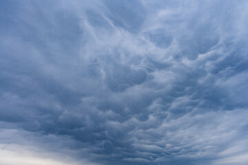 Fototapeta premium Rare mammatus cloud shapes float above Bavaria showing dramatic weather movement and natural sky texture in Germany