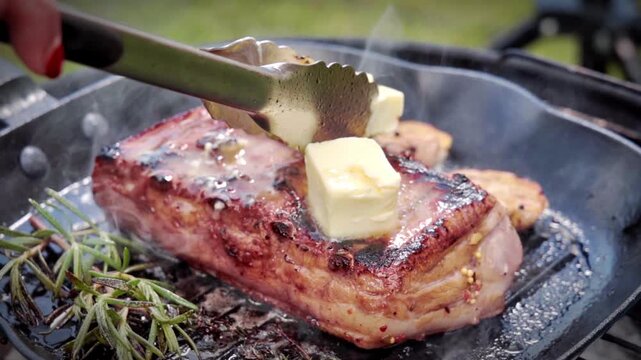 detailed view of butter application on grilled pork to achieve shiny finish and caramelization. Slow motion footage 100fps.