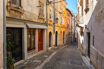 Picturesque street with cobbled floor and colorful old houses in the coastal town of Piran, Slovenia.