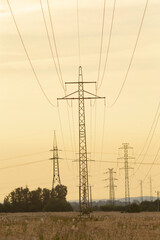 Silhouetted power lines stretch across a serene rural landscape during sunset, showcasing the beauty of nature and infrastructure in harmony.