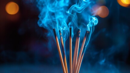Burning incense sticks with soft, rising smoke creating a calm and meditative atmosphere against a dark background. Concept of spirituality, relaxation, mindfulness, and aromatherapy.