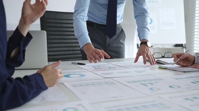 Business team analyzing financial charts and graphs during strategy meeting in modern office, focusing on corporate planning, data analysis, and decision making - Powered by Adobe