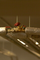 Close-up of a valve on industrial piping, showcasing the detailed design and materials used in facility plumbing and HVAC systems.