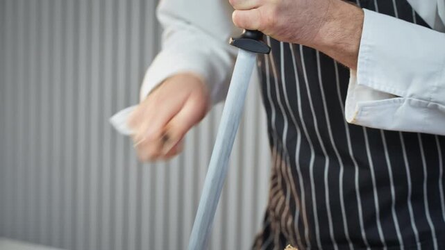 closeup of chef refining knife precision, expert chef using steel rod to sharpen culinary tools