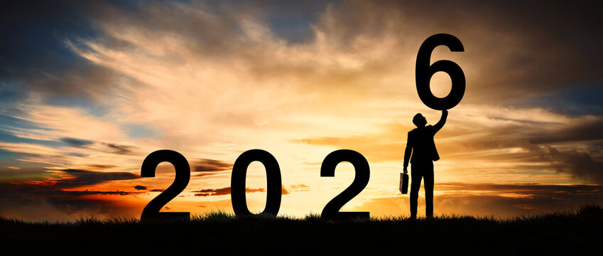 Silhouette of an enterprising businessman standing at dawn already active and motivated, greeting card for the new year 2026.