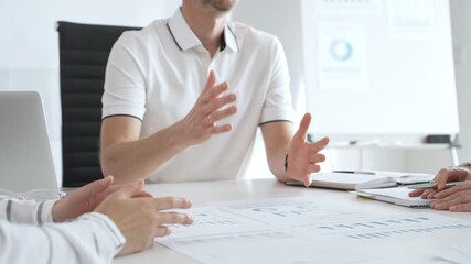 Business people team reviewing financial charts, collaborating intently around conference table in contemporary workspace, sharing insights during strategic planning session - Powered by Adobe