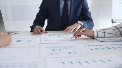 Business people discussing financial reports and marketing charts during corporate meeting, focusing on strategy, planning, data analysis, and teamwork in modern office - Powered by Adobe