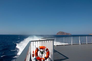 Orange Lifebuoy with rope on the quay in the old port on the Sea, blue sky, copy space