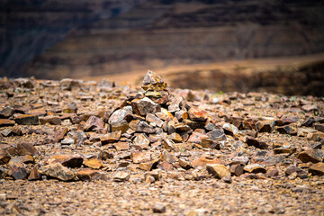A dramatic view of the Fish River Canyon in Namibia, showcasing steep rocky cliffs, layered geological formations, and a winding riverbed cutting through the arid desert landscape. 