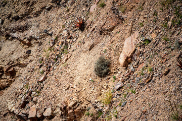 A dramatic view of the Fish River Canyon in Namibia, showcasing steep rocky cliffs, layered geological formations, and a winding riverbed cutting through the arid desert landscape. 