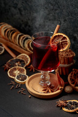 Mulled wine with ingredients and dry orange slices.