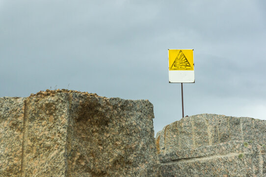 Explosion Hazard Sign in Quarry with Cloudy Sky Background.