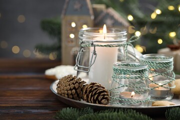 Christmas lanterns, cookies and festive decor on wooden table against background with blurred lights, space for text. Bokeh effect