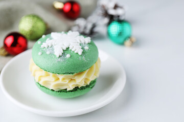 Tasty macaron and Christmas decor on white table, closeup. Space for text