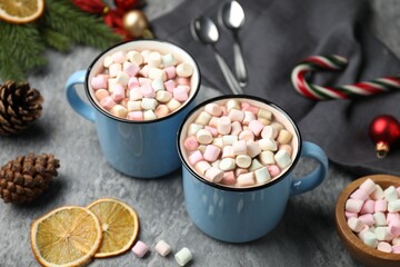 Tasty cocoa with marshmallows and Christmas decor on grey table, closeup
