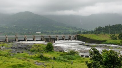 Scenic View of Dam with Overflowing Water During Monsoon Season in Lush Green Landscape