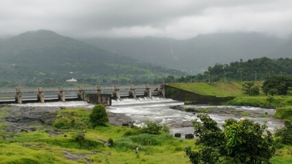 Scenic View of Dam with Overflowing Water During Monsoon Season in Lush Green Landscape