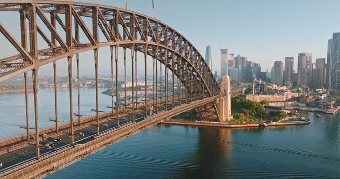 Close up view Sydney Harbor Bridge arch over Sydney Harbor, connecting north shore to bustling central business district, small boat navigating the waters. Architecture and transport. Aerial panorama