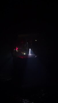 Rescue forces search for survivors inside a dark tunnel using flashlights