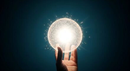 A hand holding a glowing orb with radiating sparkles against a dark teal colored background