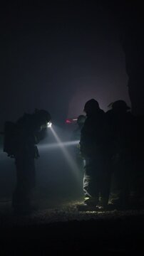 Rescue forces search for survivors inside a dark tunnel using flashlights