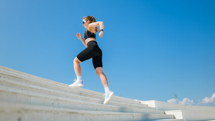 Fototapeta premium Female runner exercises on outdoor stairs