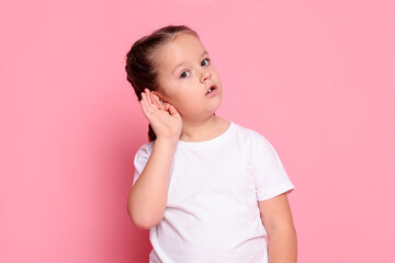 Girl showing hand to ear gesture on pink background