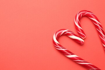 Fototapeta premium Heart made of tasty candy canes on red background, flat lay with space for text. Merry Christmas and Happy New Year