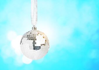 Christmas disco ball on light blue background, space for text. Shiny ornament