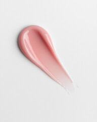 Pink glossy cosmetic cream smear on white background