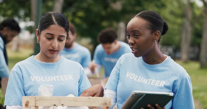 Volunteer, communication or people in park with tablet, group or package checklist in eco friendly project. Team, coordination or NGO outdoor with tech, inventory track or advice in charity donation.