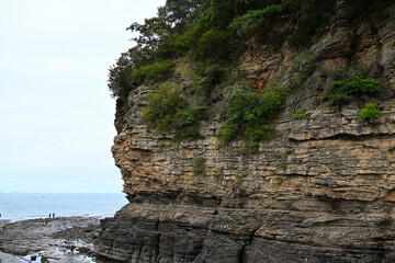 A rocky cliff with a view of the sea