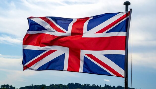 Union Jack flag glowing in sunlight against cloudy sky and mountain backdrop. - Powered by Adobe