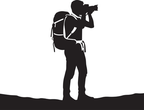 Silhouette of a photographer with backpack on a landscape taking a photo