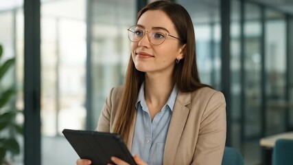 Thoughtful Young Businesswoman in Glasses Holding Digital Tablet in Modern Office, Looking Away with a Pensive Smile - Powered by Adobe