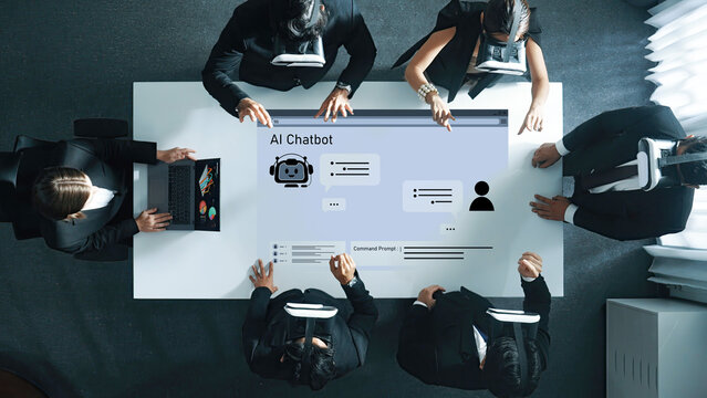 Business professionals engage in a collaborative discussion about AI chatbot technology, showcasing teamwork and innovative strategies in a modern office environment. Trope - Powered by Adobe