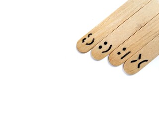 Happy, neutral, and sad emoji on wooden craft stick. mental health awareness concept. Copy space 
