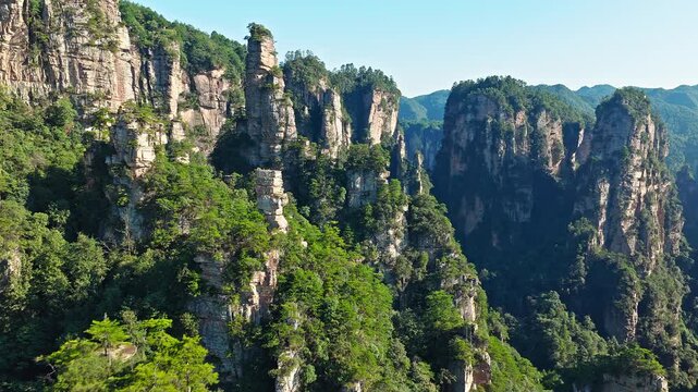 Aerial shot of the spectacular Zhangjiajie national forest park with towering sandstone pillars and lush green forest in Hunan, China.