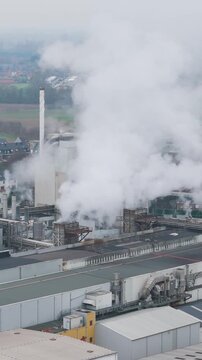 industrial factory oudegem belgium steam chimneys smoke activity associated recycling close up forward aerial drone shot view vpk packaging group 