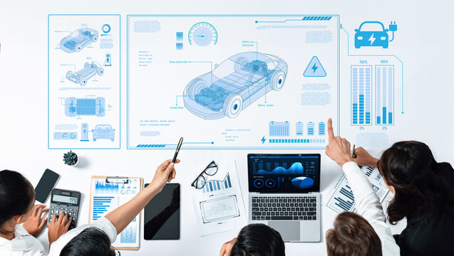 A collaborative team analyzes electric vehicle designs through data visualization and tech tools, highlighting innovation in automotive engineering and sustainability trends. Trope