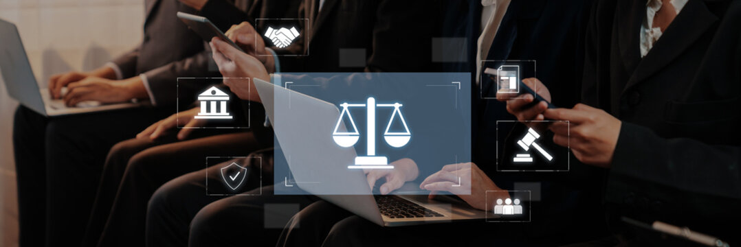 A scene showing business professionals engaged in legal discussions with laptops and smartphones, emphasizing modern communication in the legal field and collaboration. Trope