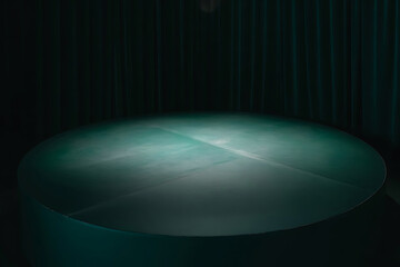 green round stage with soft studio lights coming from the top on dark background
