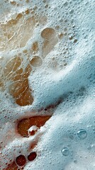An abstract close-up of soap bubbles and liquid, revealing intricate textures and a blend of colors.