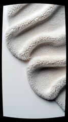 A detailed, abstract view of a folded piece of cream-colored sherpa fabric, highlighting its soft texture and fluffy edges.